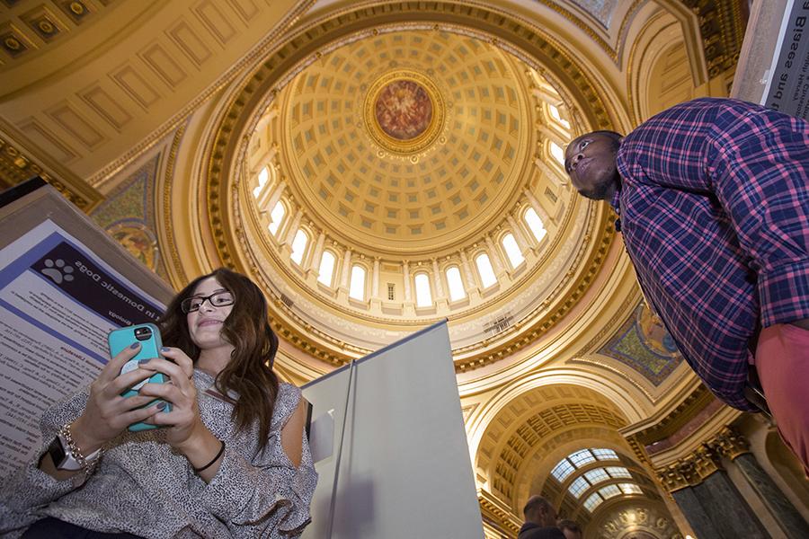 Two students stand in the Rotunda of the Wisconsin State Capitol building.