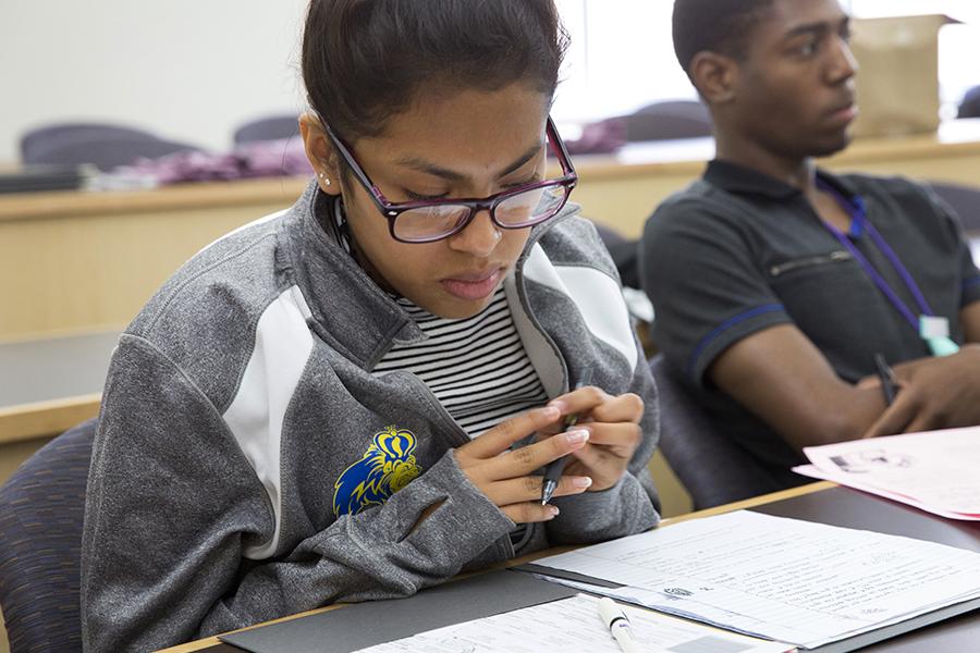 A student in a classroom looks down at her notes.