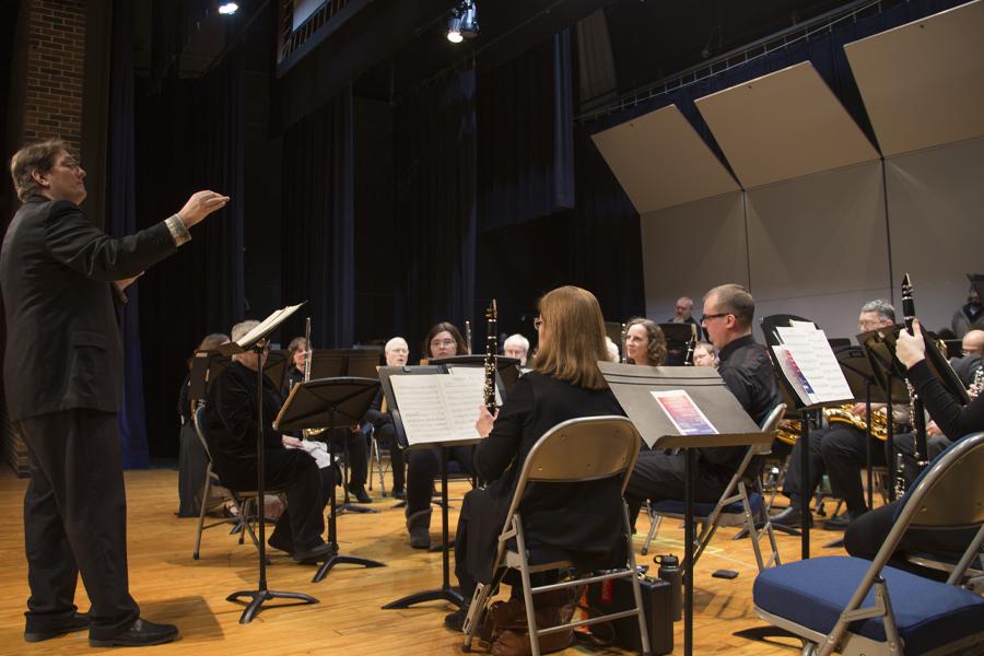 A faculty member conducts students in the Kirk Denmark Auditorium.